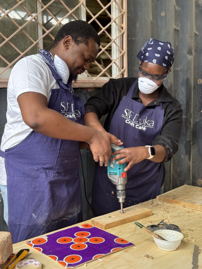 The Craft Cafe, student teaches another student how to use drill